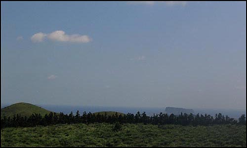 분화구에 서면 성산일출봉과 우도, 용눈이오름이 한 눈에 보인다. 